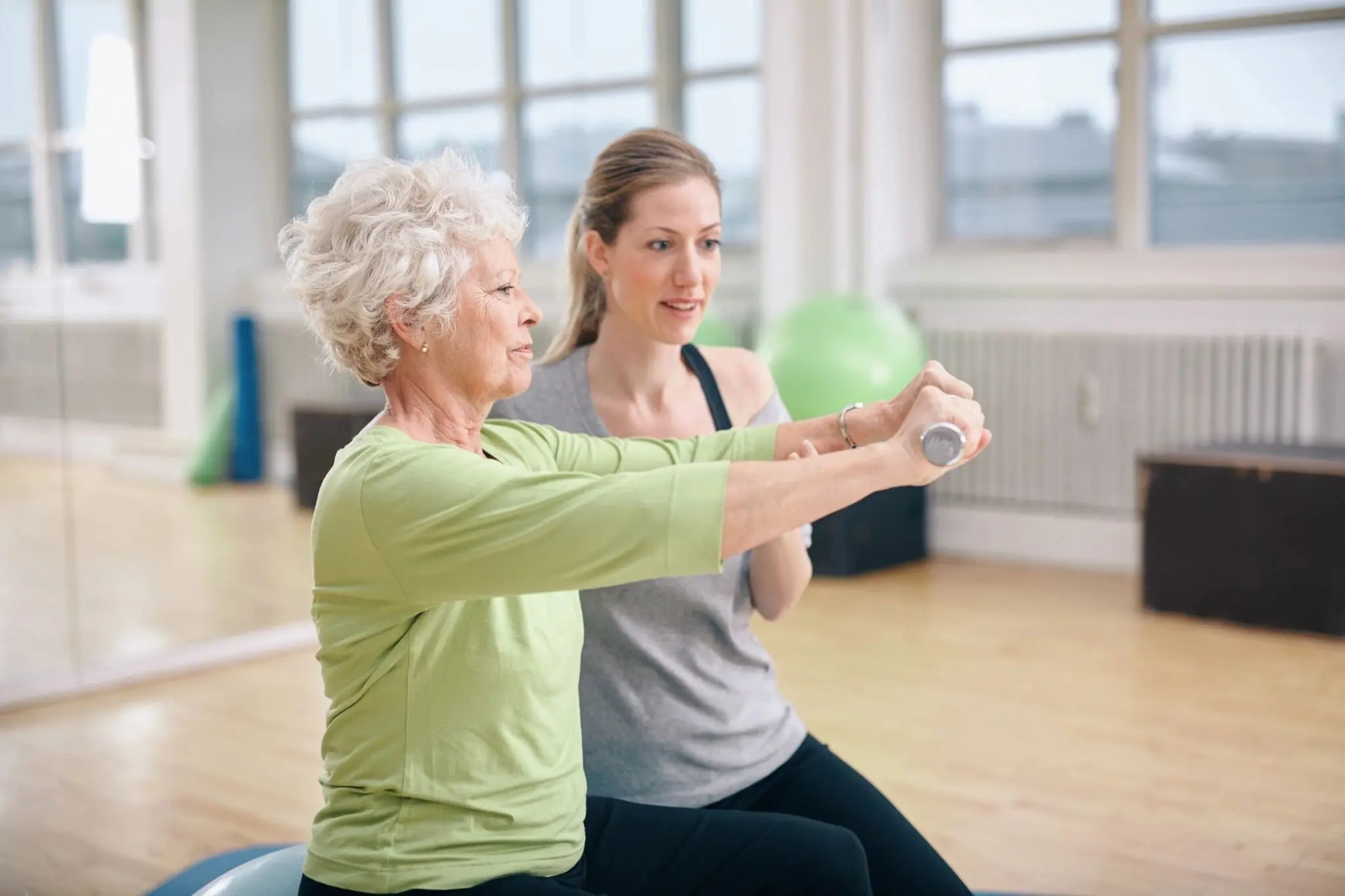 A woman and an older person are doing exercises.